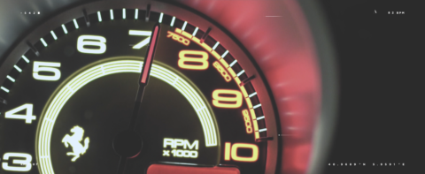 Gros plan d'un compteur de vitesse Ferrari illuminé indiquant les RPM