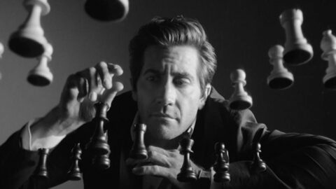 Homme concentré jouant aux échecs avec des pièces en lévitation, en noir et blanc