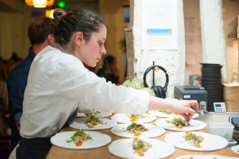 Chef en cuisine, dressant des assiettes gastronomiques.