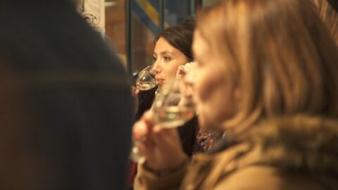 Personnes dégustant du vin blanc lors d'un événement de dégustation.