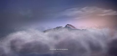 Des montagnes enneigées émergent des nuages sous un ciel étoilé aux teintes pastel.