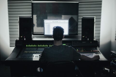 a photography of a male sound designer, from back, at his desk